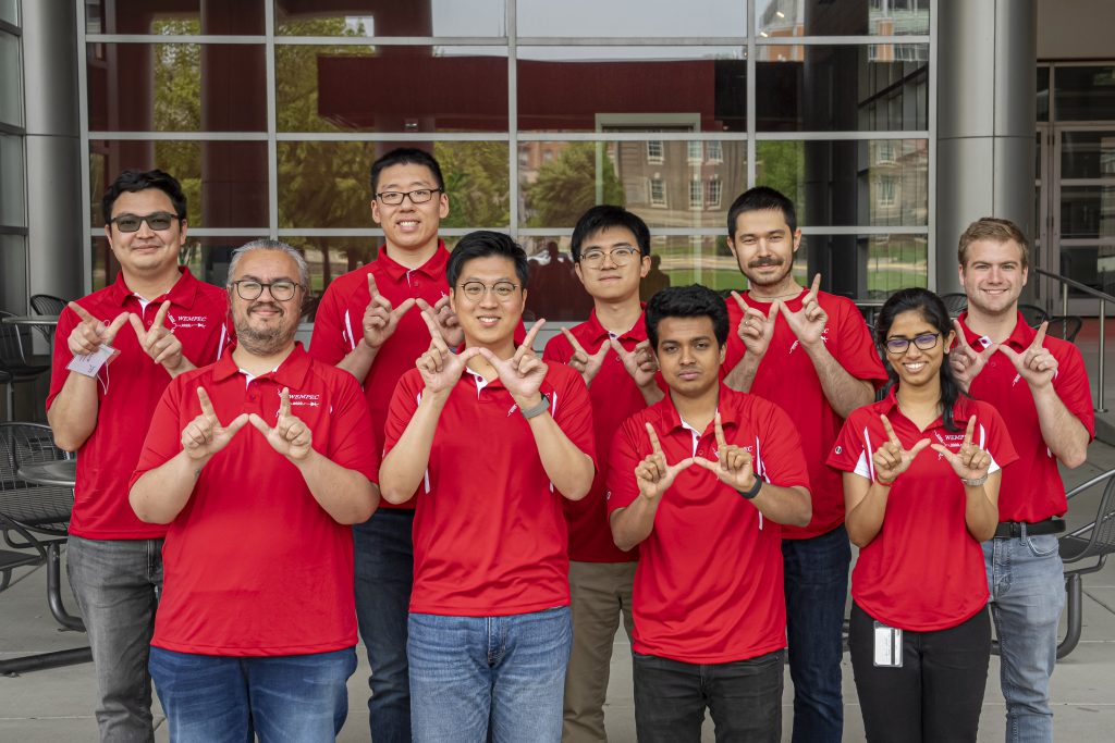 A group of students making the UW 'W' with their hands.