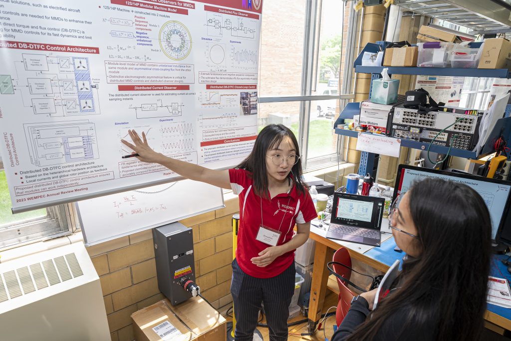A student explaining their poster to a member company representative.