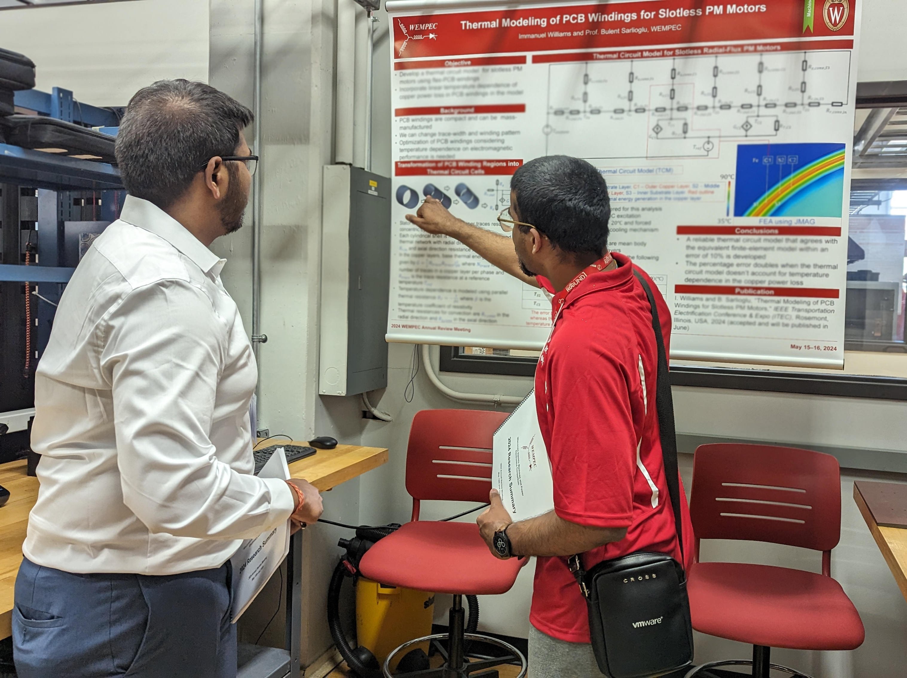 A student explaining their poster to a member company representative.