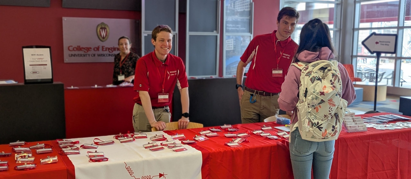Check-in table staffed by students at the WEMPEC Annual Review 2025