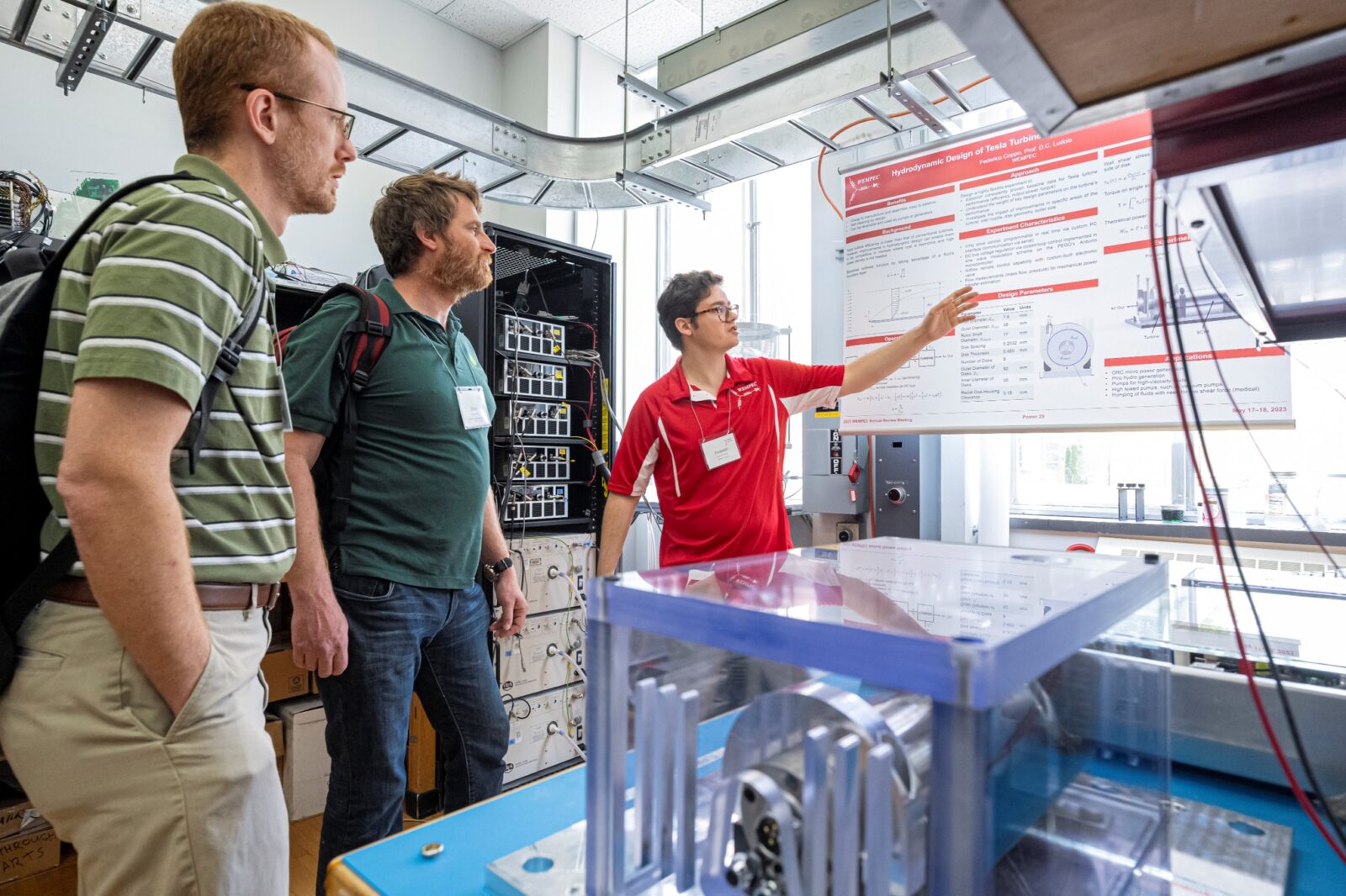 Graduate student and industry members talking over the students' research at his poster during the Annual Review